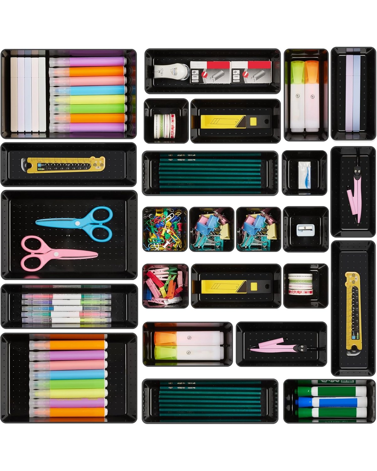 An open desk drawer showing 25 matte-black organizer trays of four sizes arranged in a grid, holding paper clips, sticky notes, rubber bands, and small office tools by category.