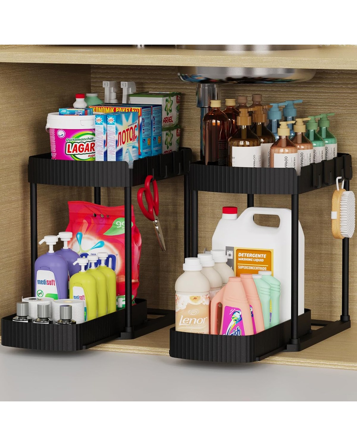 Two white slide-out cabinet organizers installed inside a lower kitchen cabinet, the front one pulled open to reveal neatly arranged cleaning supplies and snacks on tiered shelves.
