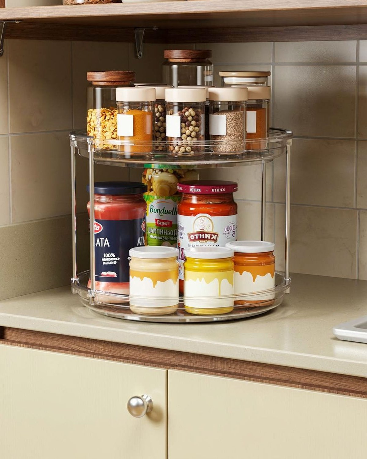 A clear two-tier rotating turntable with a raised lip, shown holding spice jars and condiments.