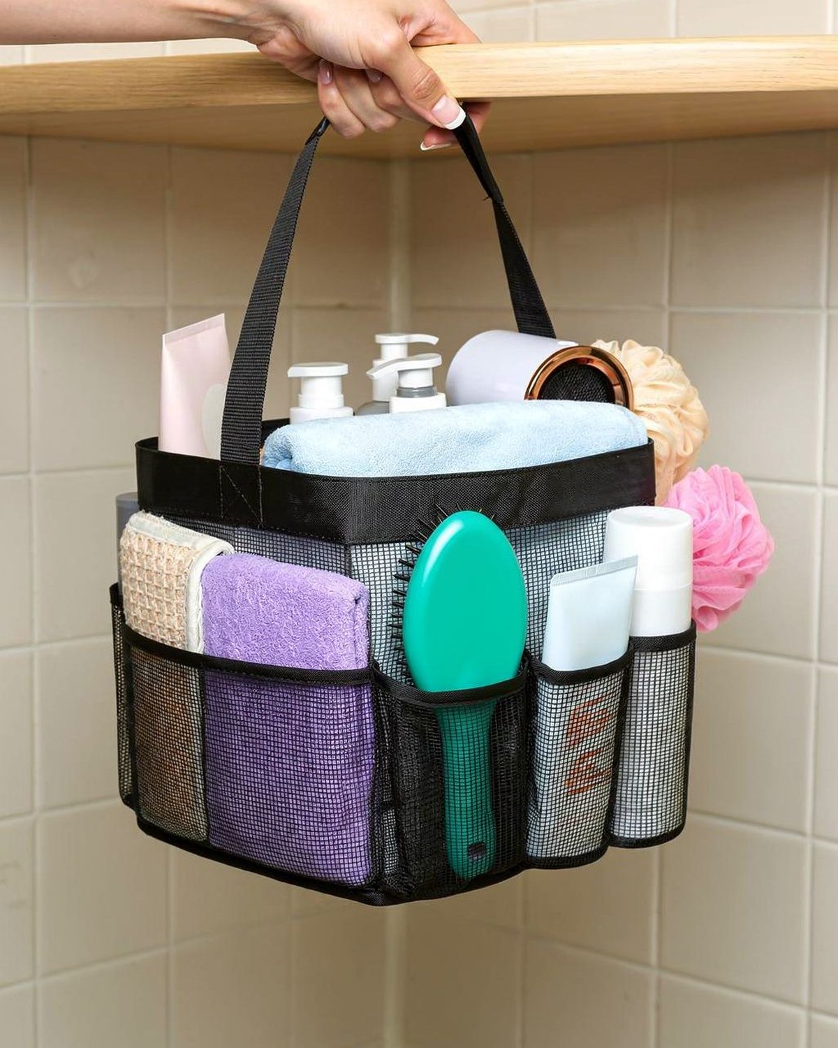 Portable mesh shower caddy with multiple pockets holding toiletries, ready to carry to a shared bathroom