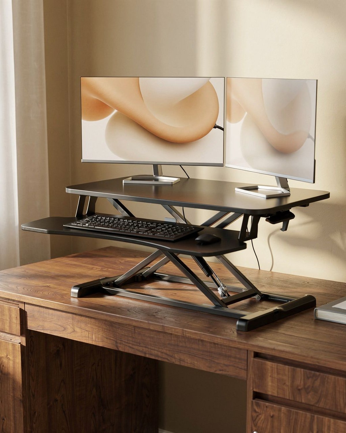 Height-adjustable standing desk converter raising a monitor and keyboard above a desk