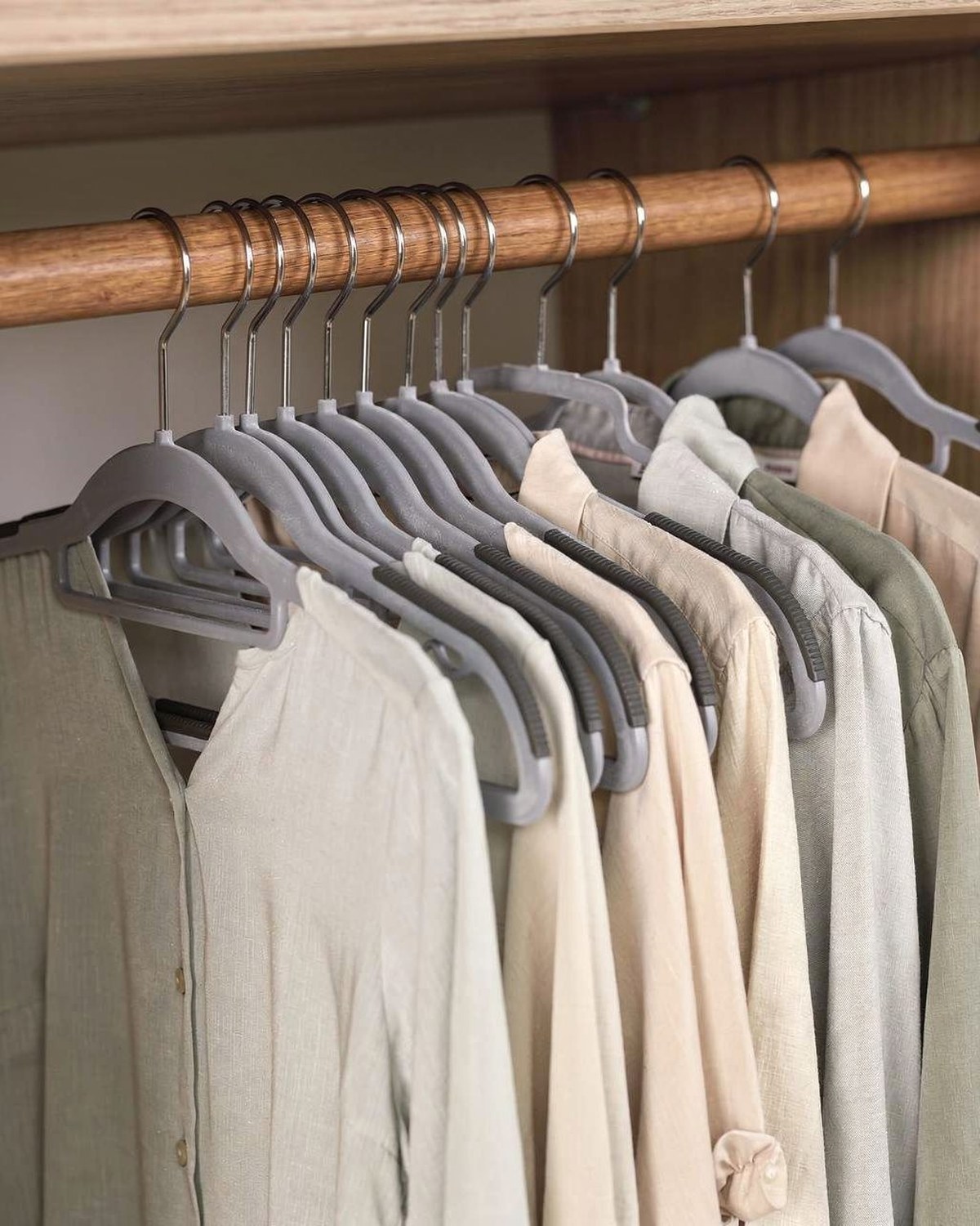 Row of matching slim velvet hangers on a closet rod holding clothes close together
