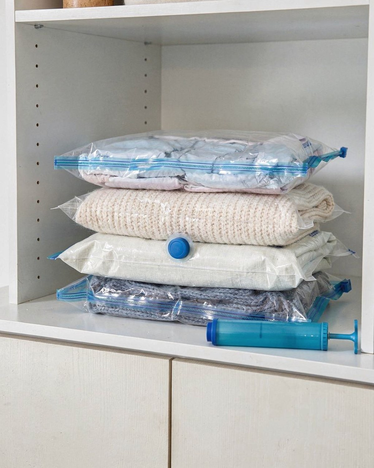 Set of vacuum storage bags compressing folded off-season clothes flat for closet storage
