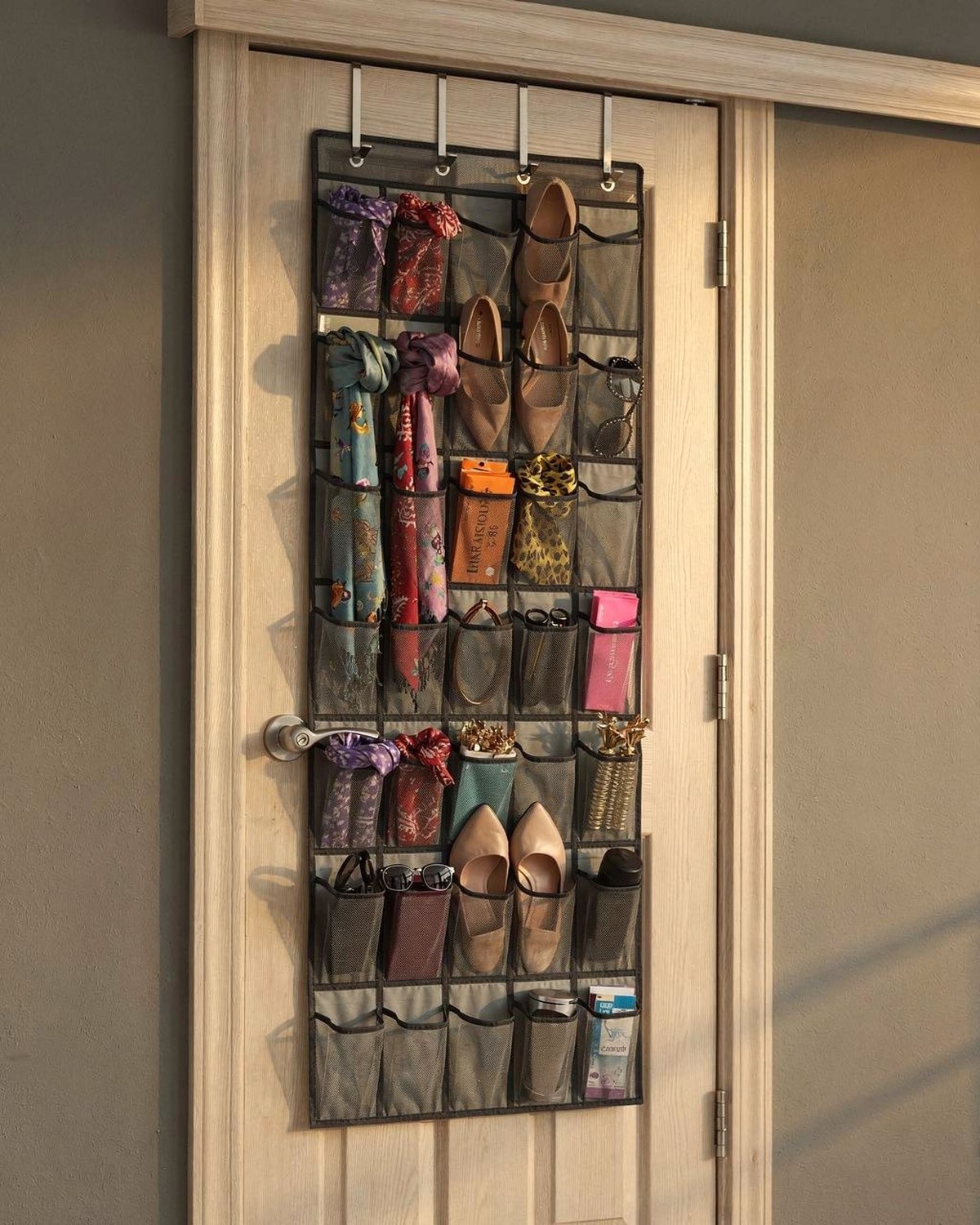 Over-the-door organizer with clear pockets holding shoes and accessories on a closet door