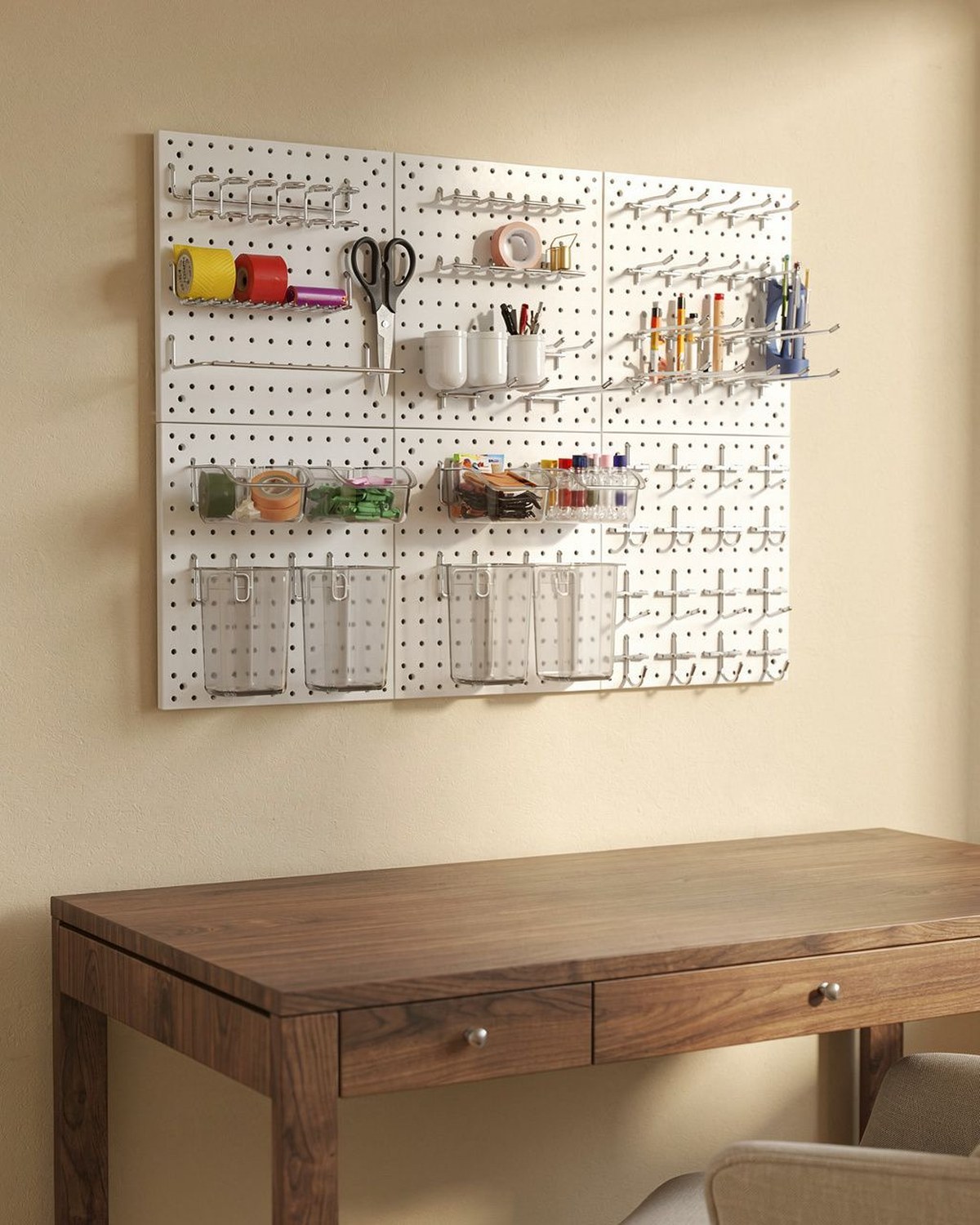 Square wall-mounted pegboard organizer holding desk supplies above a clear desktop